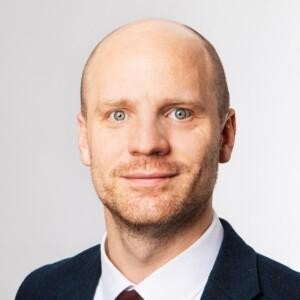 Photo of Niklas Helwig wearing a suit and tie.