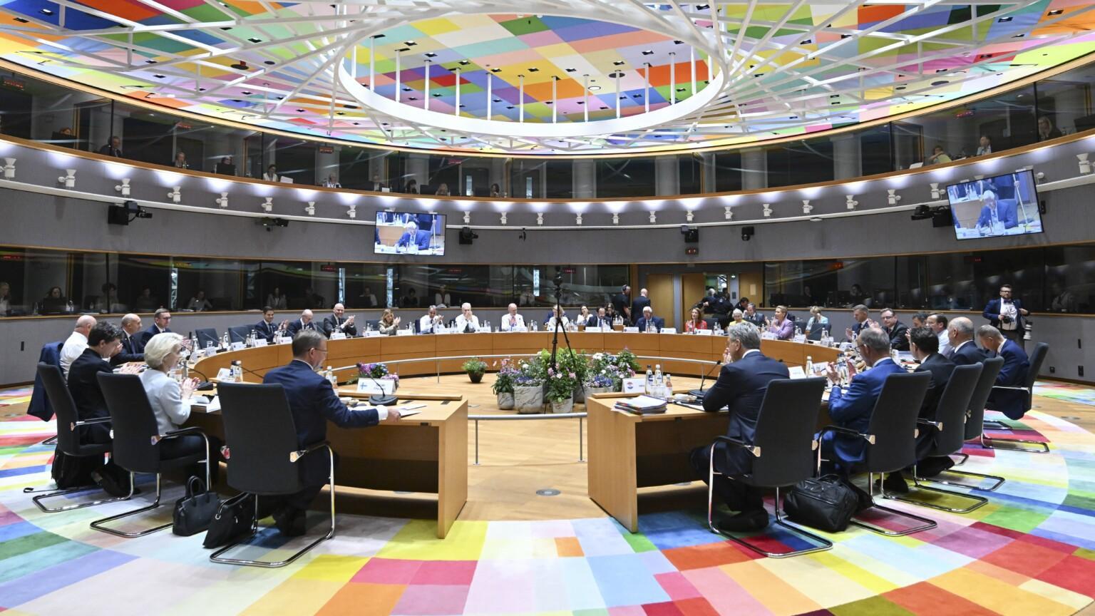 Heads of European states around a round table at the Council of Europe. The room has colourful floor and ceiling.