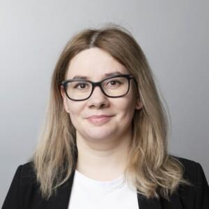 Photo of Margarita Zavadskaya wearing glasses, white shirt and a black blazer.